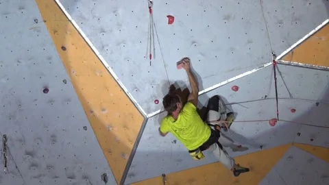 Young athletic man climbs artificial rock wall during the sport competition. Stock Footage 85054830
