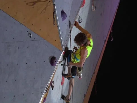 Young athletic man climbs artificial rock wall during the sport competition. Stock Footage 85063501