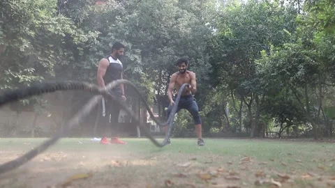 Young Athletic  Man Doing Battle Rope Exercise at home ground Stock Footage 144262047
