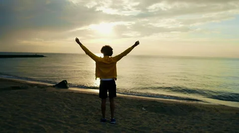 Young athletic man doing gymnastics on the sea early in the morning Stock Footage 50210463