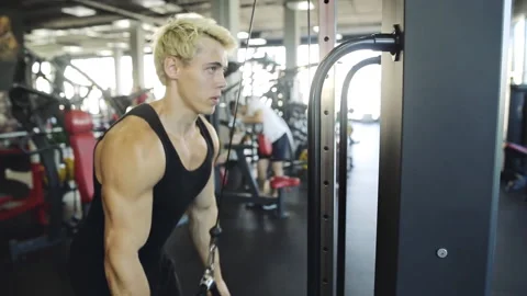 Young athletic man doing pull down exercise for triceps at the gym 스톡 동영상 93789045