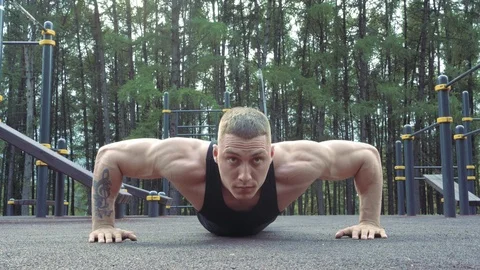 Young athletic man doing pushups outdoors Stock Footage 114362337