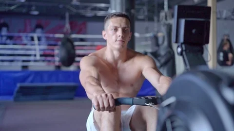 Young athletic man doing rowing machine workout at the gym Video stock 94130950