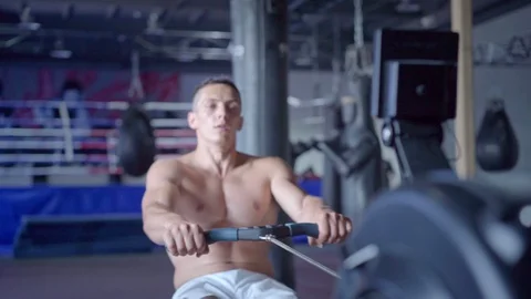 Young athletic man doing rowing machine workout at the gym Video stock 94131047