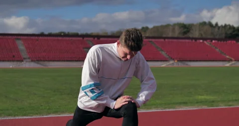 Young athletic man doing stretching and warming up before jogging at the stadium 库存影片 135324499