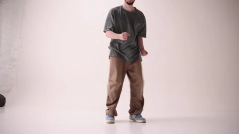 Young athletic man dressed streetstyle clothes dancing modern breakdance against Stock Footage 303347960