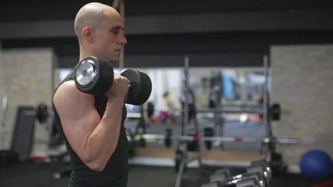 Young athletic man exercise bicep curls with dumbbells Stock Footage 71609124