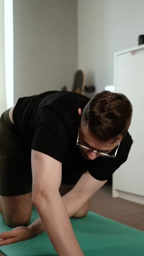 A young, athletic man exercises at home Stock Footage 335209642