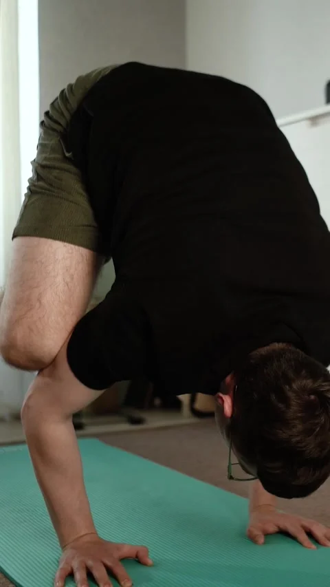 A young, athletic man exercises at home Stock Footage 335209643