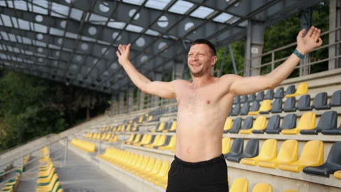 Young athletic man, exercises. Training alone outdoors. Raises hands up, jumps Stock Footage 159412647