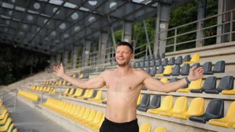 Young athletic man, exercises. Training alone outdoors. Raises hands up, jumps Stock-Footage 161222255