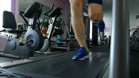 Young athletic man exercising and running on treadmill in sport gym. Stock Footage 98947954