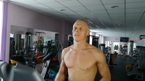 Young athletic man exercising and running on treadmill in sport gym. Stock Footage 98947971