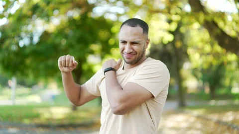 A young athletic man feels sharp pain in his shoulder during morning exercise  Stock Footage 234877254