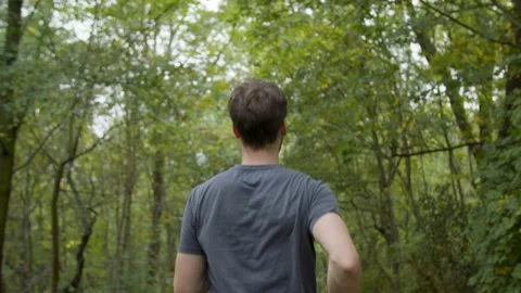 Young Athletic Man jogging/walking in the Forest Видео 132865469
