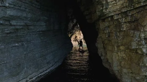 Young athletic man rowing with paddle standing on SUP board and swim into narrow Video stock 145236533
