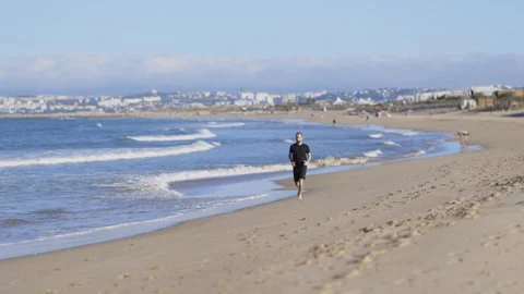 Young athletic man running on a sandy beach Stock Footage 320462622