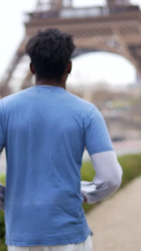 Young athletic man running towards eiffel tower Stock Footage 327456907