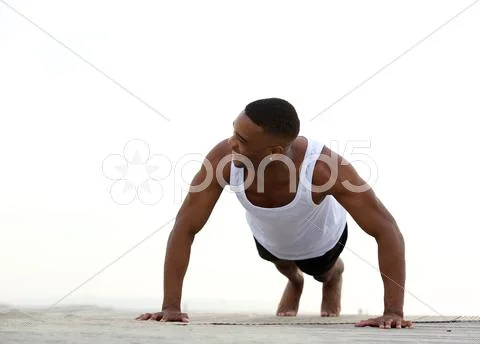 Young athletic man smiling and doing push ups Stock Photos