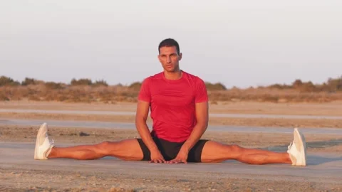 Young athletic man stretching after exercising and looking at sunset Stock Footage 132070041