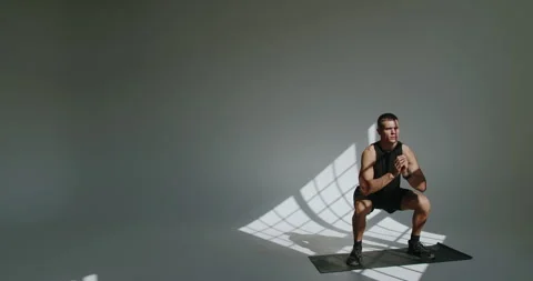 Young Athletic Man Training in a Studio, Shadow Patterns on Wall Stock Footage 344278289