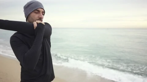 Young athletic man warming up before workout at seaside Stock Footage 132040419