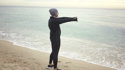Young athletic man warming up before workout at seaside Stock Footage 132040590