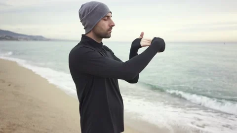 Young athletic man warming up before workout at seaside Stock Footage 132040836