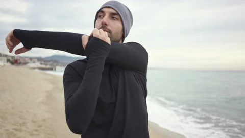 Young athletic man warming up before workout at seaside Stock Footage 132041876