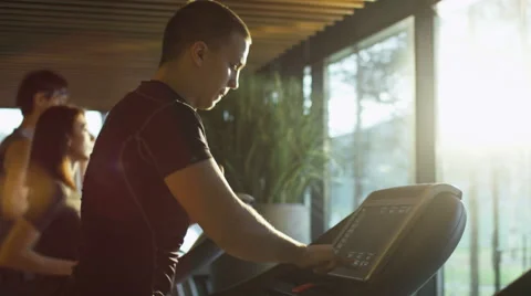 Young athletic men and women exercising and running on treadmill in sport gym Stock Footage
