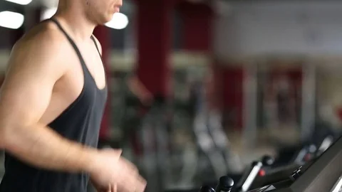 Young athletic men exercising and running on treadmill in sport gym Stock Footage 73890094