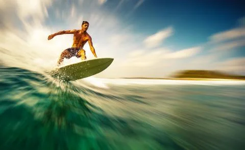 Young athletic surfer rides the wave in tropics with splashes. Sultans surf s Stock Photos