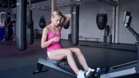 Young athletic woman doing rowing machine workout at the gym Video stock 94130676