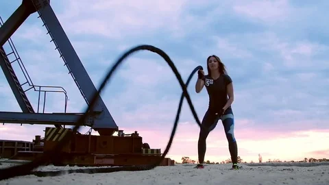 Young, athletic, woman, performs strength exercises with the help of a thick Stock Footage