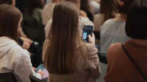 Young attendees absorb information at a technology talk, presenter with visual Stock Footage 268873329