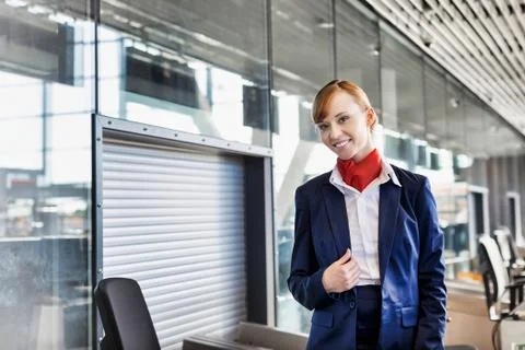 Young attractive airport security personnel standing against x-ray baggage sc Stock Photos
