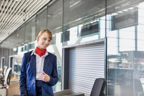 Young attractive airport security personnel standing against x-ray baggage sc Stock Photos