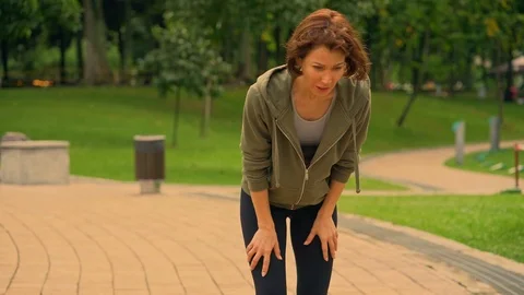 Young attractive and exhausted runner woman hoodie after running in citypark Stock Footage 113136901