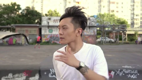 Young attractive Asian man dancing outdoors. Modern street hip-hop dancer Stock Footage 159063359
