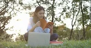 Young Attractive Asian Woman Sitting In A Summer Park On The Grass And Reading A Stock Footage