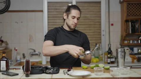 Young attractive barman using lemon squeezer to obtain juice for cocktail. Puts Stock Footage 205318162