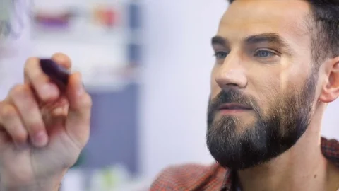 Young attractive bearded man architect writing on glass board office Stock Footage 77795993