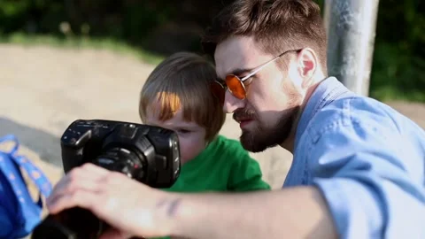 Young attractive bearded man teaching little excited blonde boy to use Stockbeeldmateriaal 130805625