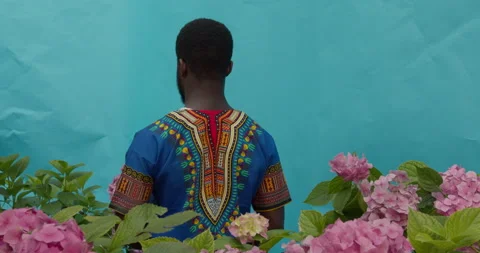 Young attractive black man posing at camera with gorgeous flowers in his hands Stock Footage 159506940