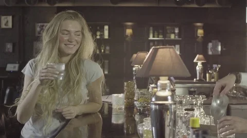 Young attractive blonde drinking whiskey with barman close-up 4k. Stock Footage 76948355
