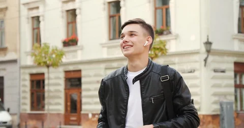 Young Attractive Boy smiles charmingly while Texting Message on his Smartphone Video stock 112156692