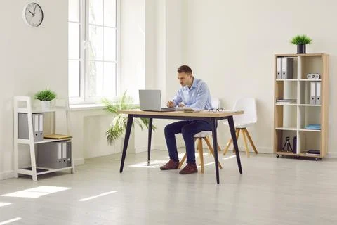 Young attractive business man working on workplace on a laptop at modern office. 写真素材