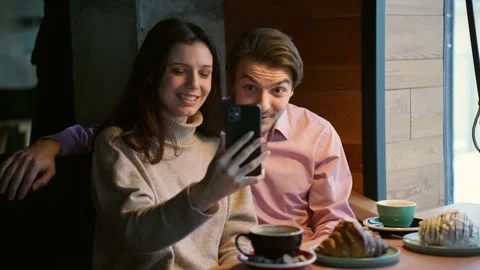 A young attractive couple communicates through a video call with friends in a Stock Footage 167980945