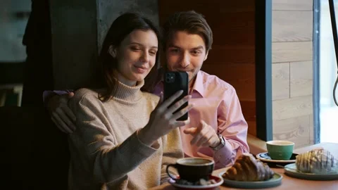 A young attractive couple communicates through a video call with friends in a Stock Footage 167995665