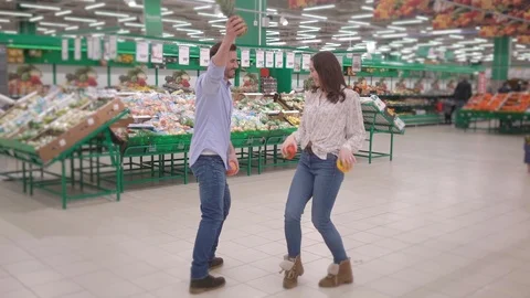Young attractive couple dancing and laughing in supermarket through fresh Stock Footage 124969819